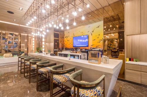 a bar with a row of stools in a restaurant at Holiday Inn Chandigarh Zirakpur by IHG in Chandīgarh