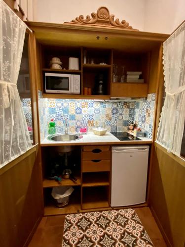 a small kitchen with a sink and a microwave at Retiro del Teatro Almagro in Almagro