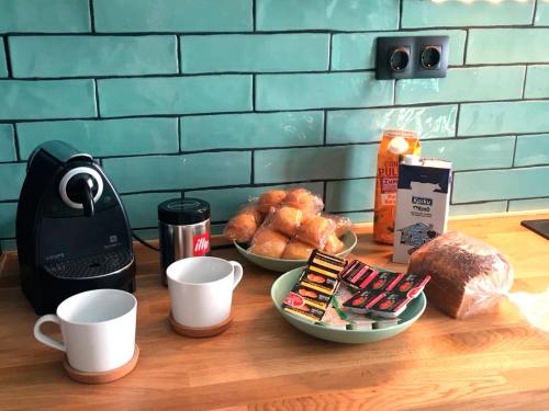 una mesa con tazas de café y bollería en Luxury Pintoreria Vitoria, en Vitoria-Gasteiz