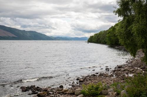 a view of a body of water with mountains at Loch Ness Drumnadrochit Hotel in Drumnadrochit
