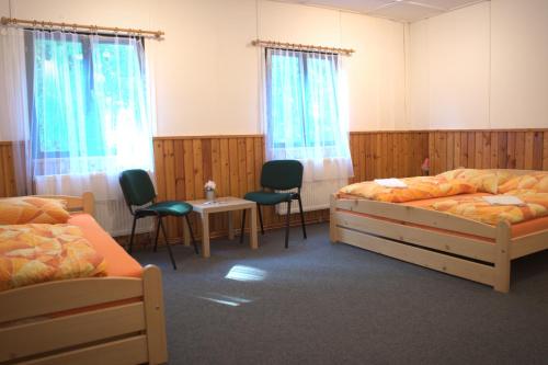 Resort Blatnice في Františkov: غرفة نوم بسريرين وطاولة وكراسي
