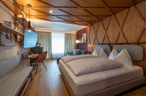 een slaapkamer met een bed en een bureau in een kamer bij Sunstar Hotel Lenzerheide in Lenzerheide