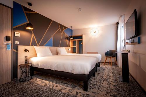 מיטה או מיטות בחדר ב-ibis Styles Valenciennes Petite Foret
