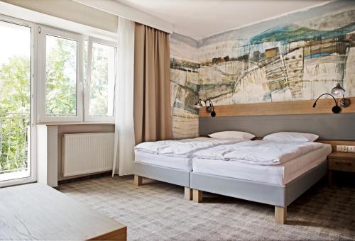 a bedroom with two beds and a painting on the wall at Dom Wczasowy Beskidy in Wisła