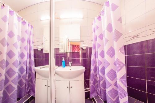 a purple and white bathroom with a sink and a mirror at Pensiunea Mariana in Baia de Fier