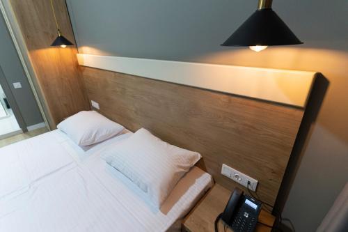 a bedroom with a bed with a phone on it at boulevard apartments in Batumi