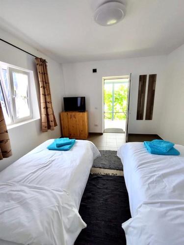 two beds in a room with a room with a window at Casa Anna in Chilia Veche