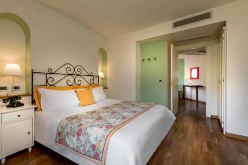 a bedroom with a large white bed with orange pillows at Bijou Hotel in Saint Vincent