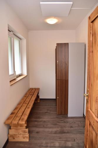 a room with a wooden bench and a refrigerator at Pension U Krbu in Mikulov v Krušných Horách