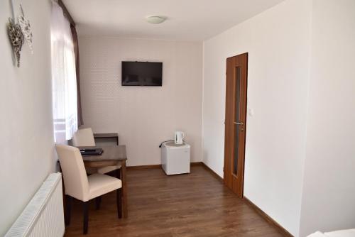 a room with a desk and a table and a television at Pension U Krbu in Mikulov v Krušných Horách