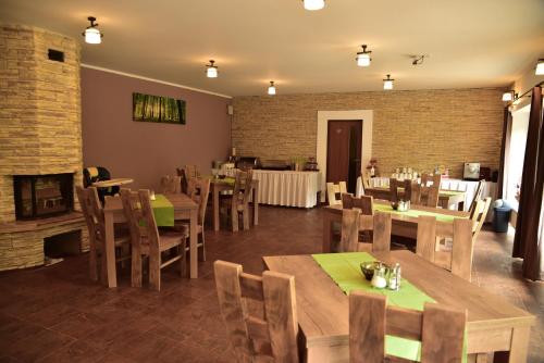 a restaurant with wooden tables and chairs and a fireplace at Pension U Krbu in Mikulov v Krušných Horách