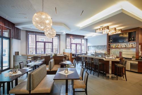 a restaurant with tables and chairs and windows at Hotel EDELWEISS Berchtesgaden Superior in Berchtesgaden