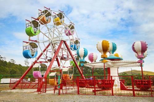 a ferris wheel at a park with red chairs at Cassino All Inclusive Resort Poços de Caldas By Nacional Inn in Poços de Caldas