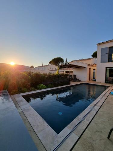 - une piscine en face d'une maison au coucher du soleil dans l'établissement Mas Partout, à Malaucène