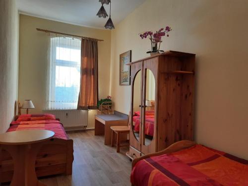 1 Schlafzimmer mit 2 Betten, einem Tisch und einem Schrank in der Unterkunft Arthur Albert Apartment -7 Wohnungen für Geschäftsreisende - wie zu Hause in Chemnitz