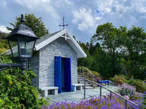 a small building with a blue door in a garden at Haaheim Gaard in Uggdal