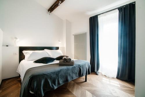 a bedroom with a bed and a large window at Caesar Suites - The House Of Travelers in Como