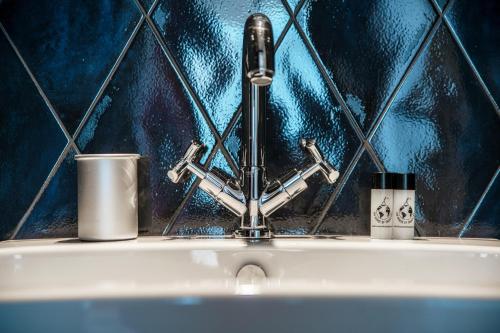 a sink with a faucet and two cups on it at Caesar Suites - The House Of Travelers in Como