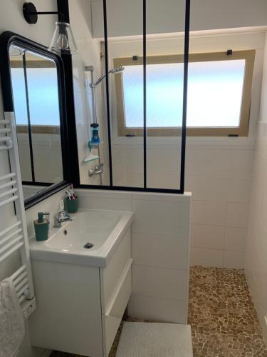 une salle de bains avec un lavabo et un miroir dans l'établissement Appartement Le Marbella, à Les Sables-dʼOlonne