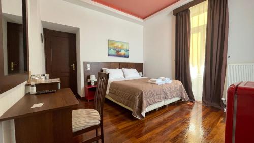 ein Hotelzimmer mit einem Bett und einem Schreibtisch in der Unterkunft Poros Mood in Poros