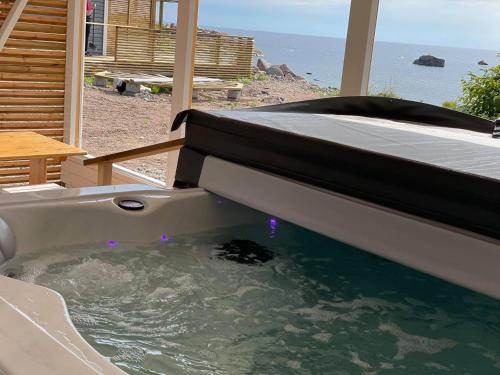 a bath tub with a bed in it with the ocean at Kaunissaaren Maja in Kotka