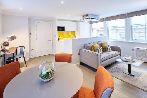 a living room with a table and chairs and a couch at Cheval Calico House in London