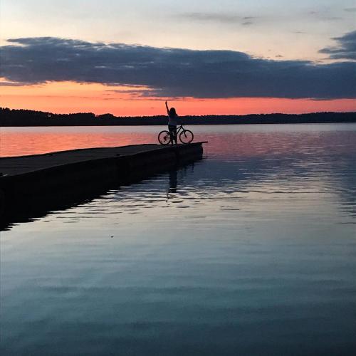 a person riding a bike on a dock in the water at Sterla - Masuria in Giżycko
