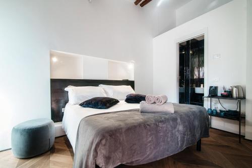 a bedroom with a large bed and a blue stool at Caesar Suites - The House Of Travelers in Como