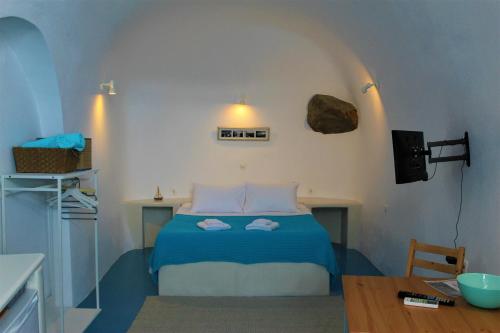 a bedroom with a bed with two towels on it at Lioyerma Cave Villa With Private Outdoor Hot Tub in Oia