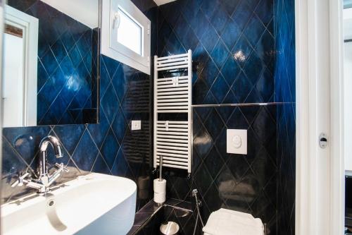 a bathroom with blue tiled walls and a sink at Caesar Suites - The House Of Travelers in Como