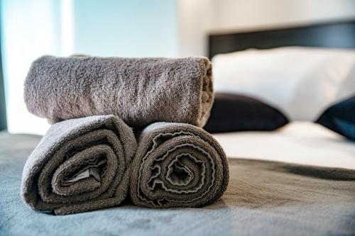 a pile of towels sitting on top of a bed at Caesar Suites - The House Of Travelers in Como