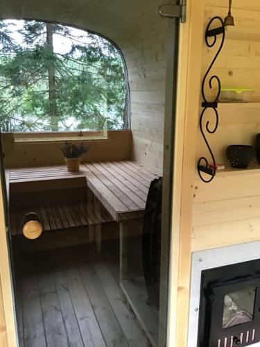 a porch in a tiny house with a window at Treehouse Čiekurs in Duķuri