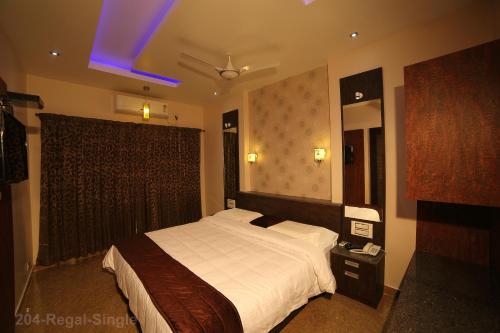 a bedroom with a large bed and a blue light at Vijaya Residency - Porur in Chennai