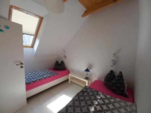 two beds in a small room with a window at No 12 in Pobierowo