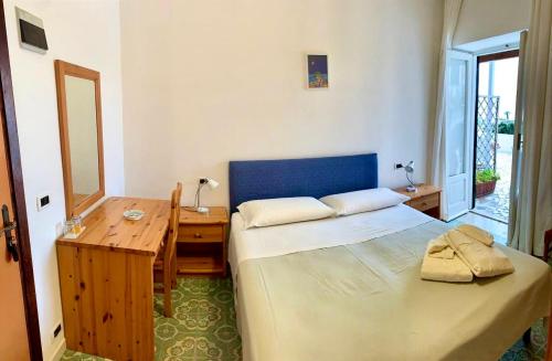 a bedroom with a bed and a wooden table and a desk at Villa Egidio in Ischia
