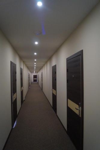 a long hallway with lockers and a row of doors at Hotel Shengen "Шенген" in Kropyvnytskyi