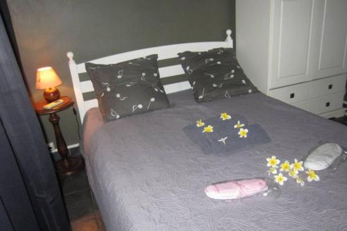 Una cama con flores y un par de zapatos. en Le Pavillon en Saint-Louis