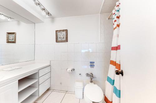 a white bathroom with a toilet and a shower at Castle Beach: Serenity Condo in Miami Beach