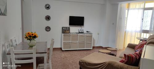 een woonkamer met een bank en een tafel met een televisie bij tranquilidad en el centro de la ciudad in Málaga