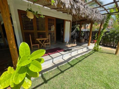 ein Haus mit einer Terrasse mit einem Tisch im Hof in der Unterkunft Vila da Praia - Barra Grande, PI in Barra Grande