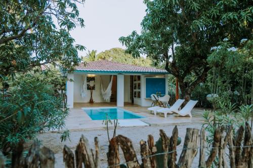 a villa with a swimming pool in a garden at Refugios Parajuru - Casa Manga in Parajuru