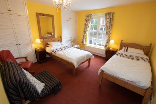 a bedroom with two beds and a chair and a mirror at The Pottery Flat Chesterfield Three Star Gold in Chesterfield