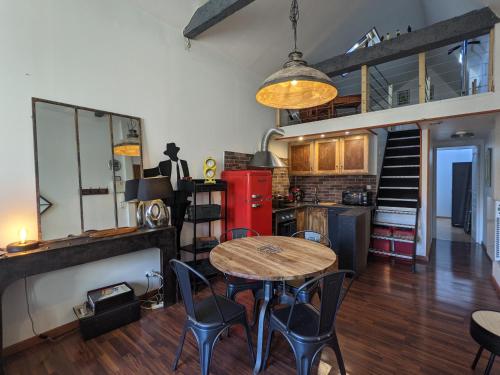 a kitchen with a table and chairs in a room at Gîte La filature in Saint-Quentin