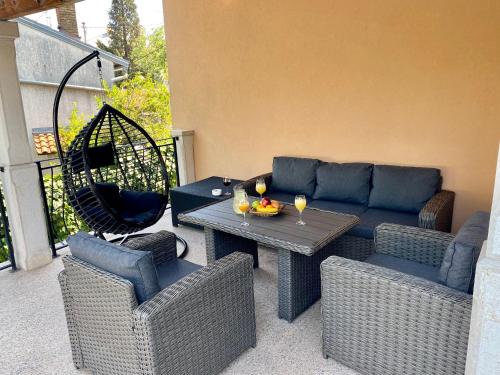 a patio with a couch and a table and chairs at Holiday Home "Opatija" in Opatija