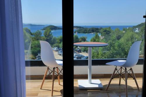 2 sillas blancas y una mesa en el balcón en Bora Bora Hotel Ksamil, en Ksamil