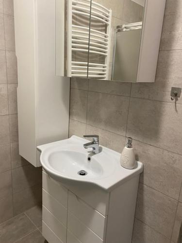 デブレツェンにあるSimonffy Central Apartmentのバスルーム(白い洗面台、鏡付)