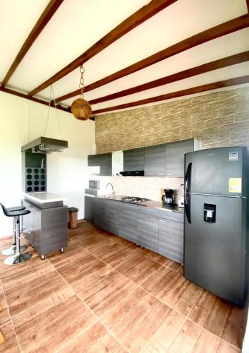 a large kitchen with a refrigerator and a table at Las Palmas Finca Turística in Filandia