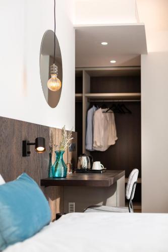 a bedroom with a bed and a vanity and a mirror at VistaLago Torbole in Nago-Torbole
