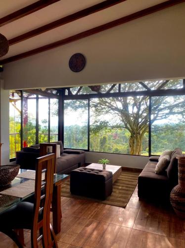 a living room with couches and a large window at Las Palmas Finca Turística in Filandia