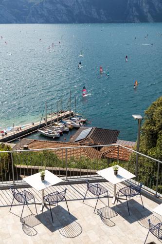a view of a beach with tables and chairs at VistaLago Torbole in Nago-Torbole